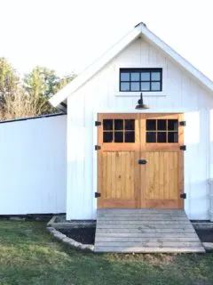 White garden shed with wooden doors