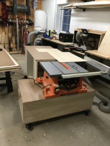 Rolling table saw with assembly cabinet as outfeed