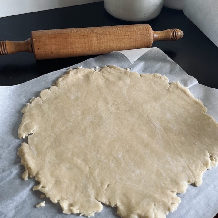 Oil pie crust flattened on parchment paper