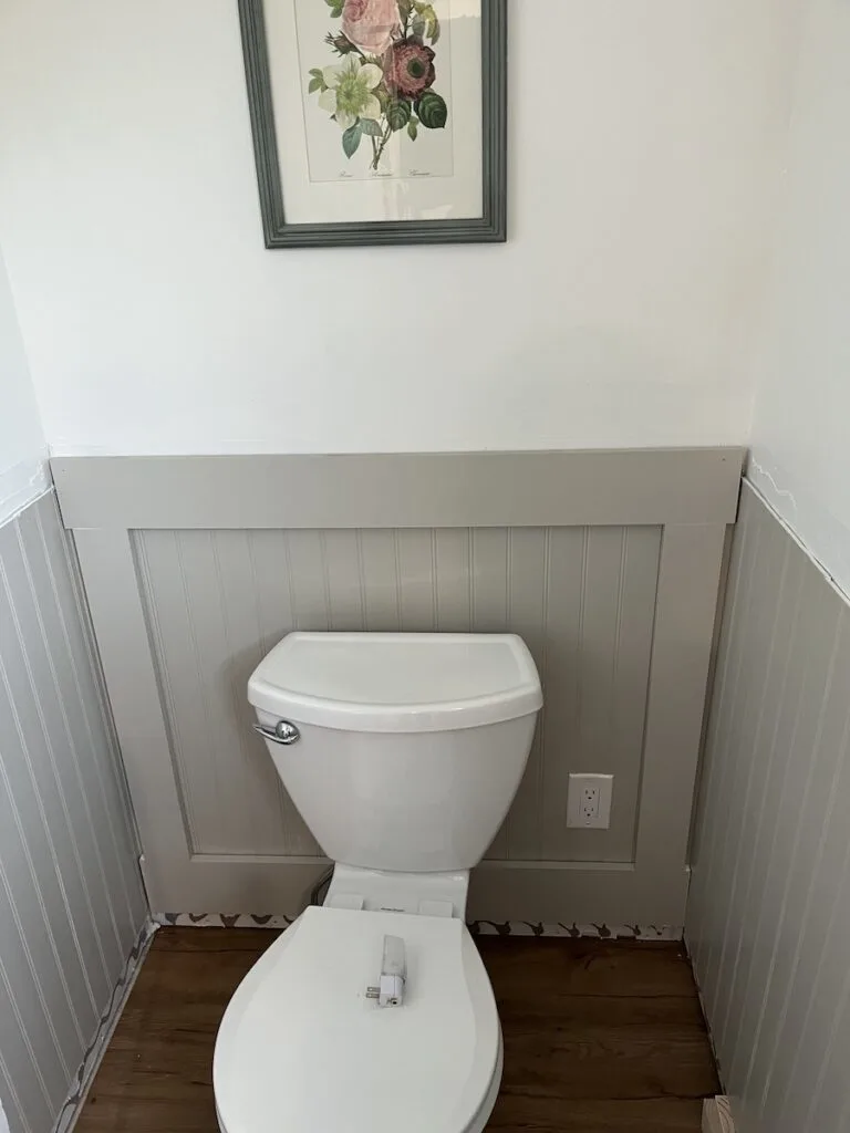 Behind the toilet, first wainscoting panel