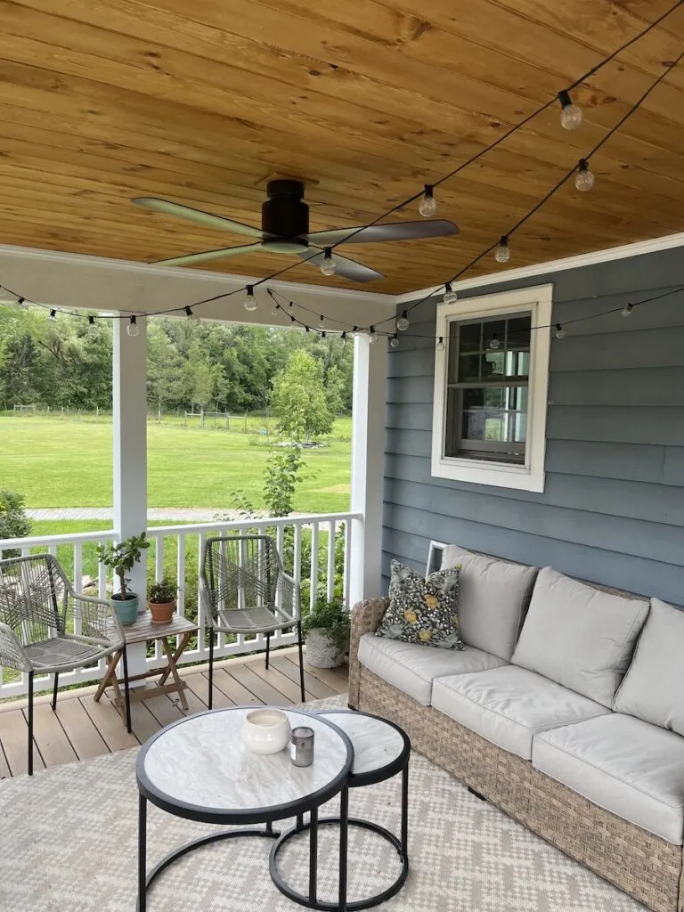 Porch with tongue and groove ceiling fan and string lights