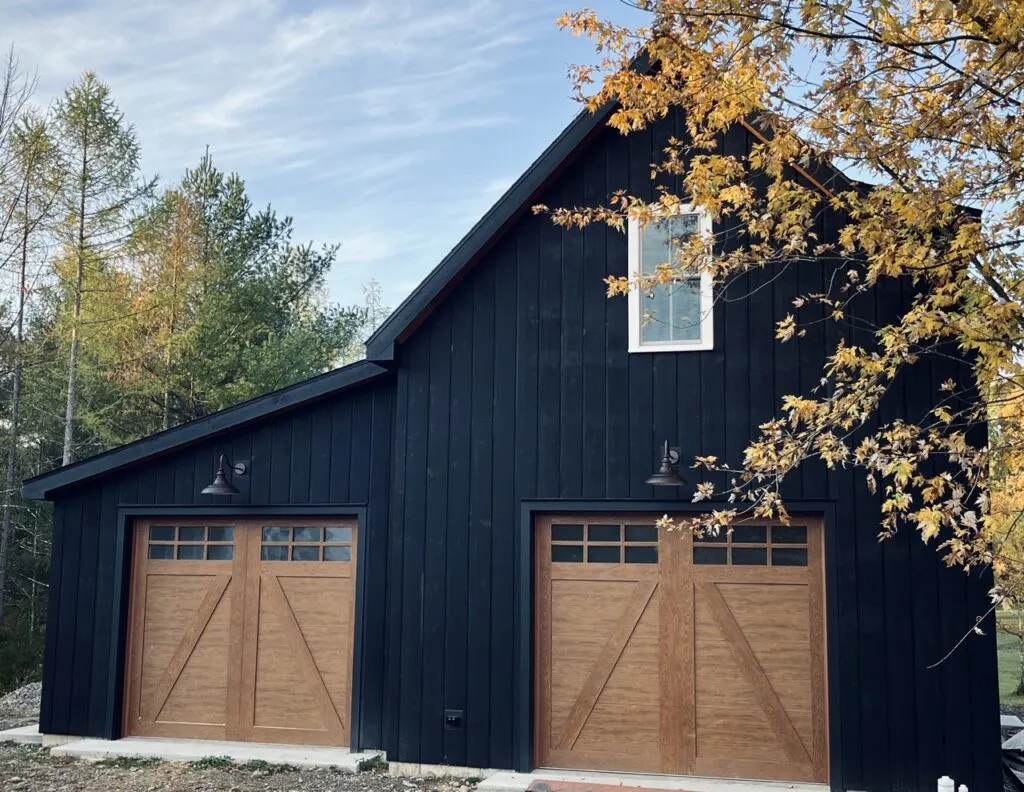 Black barn style garage with wood doors