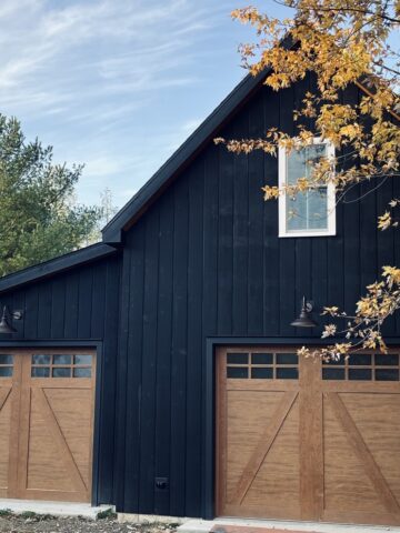 Black barn style garage with wood doors